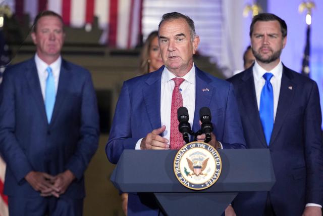 Missouri Governor Mike Kehoe speaks as Vice President JD Vance (R), and Senator Eric Schmitt (L), Republican from Missouri listen during an event about fraud enforcement at the FBI field office in Kansas City, Missouri, on September 14, 2026. (Photo by Mark Schiefelbein / POOL / AFP)