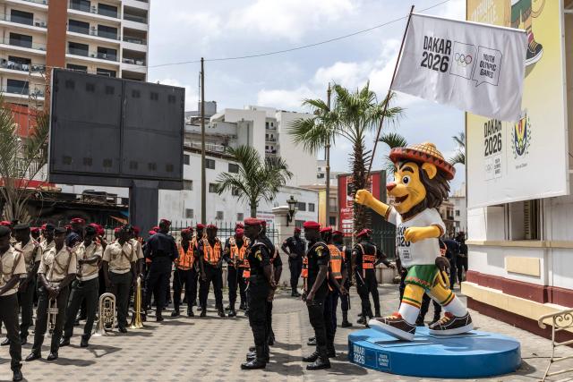 Senegalese police officers stand in formation, next to a statue of the official mascot Ayo, ahead of the ceremony marking the start of the Youth Olympic Flame's 46-day tour in Dakar, on September 14, 2026. The Youth Olympic Flame will travel across Senegal's 14 regions before returning to Dakar for the opening ceremony on October 31, 2026. Senegal will host the Summer Youth Olympic Games from October 31 to November 13, 2026, bringing together 2,700 athletes competing in 25 sports. (Photo by PATRICK MEINHARDT / AFP)