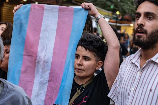 A protester holds a transgender flag during a demonstration against the arrests of LGBTQ activists in Izmir, on September 14, 2026. Turkish police fired tear gas at demonstrators in the western city of Izmir on September 14, 2026 as they protested against the growing targeting of LGBTQ activists, an AFP photographer reported. The rally came a day after police carried out sweeping nationwide raids, arresting dozens of people in a campaign the government said was aimed at promoting traditional family values. (Photo by Murat Kocabas / AFP)