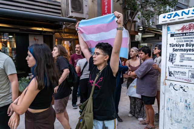 A protester holds a transgender flag during a demonstration against the arrests of LGBTQ activists in Izmir, on September 14, 2026. Turkish police fired tear gas at demonstrators in the western city of Izmir on September 14, 2026 as they protested against the growing targeting of LGBTQ activists, an AFP photographer reported. The rally came a day after police carried out sweeping nationwide raids, arresting dozens of people in a campaign the government said was aimed at promoting traditional family values. (Photo by Murat Kocabas / AFP)