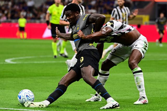 Inter Milan's French forward #09 Marcus Thuram fights for the ball with Udinese's Belgian defender #27 Christian Kabasele during the Italian Serie A football match between Inter Milan and Udinese at the San Siro Stadium in Milan, Italy on September 14, 2026. (Photo by Piero CRUCIATTI / AFP)