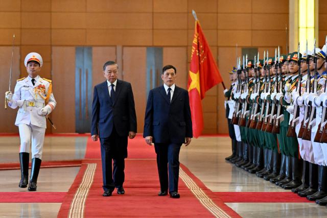 Vietnam's President To Lam (centre L) and Thailand's King Maha Vajiralongkorn (R) review honour guards during a welcome ceremony at the National Assembly House in Hanoi on September 15, 2026. (Photo by Nhac NGUYEN / AFP)