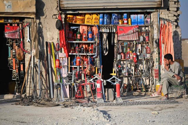 An Afghan man sits in front of a shop along a street in Spin Boldak district of Afghanistan's Kandahar province on September 15, 2026. (Photo by Sanaullah SEIAM / AFP)