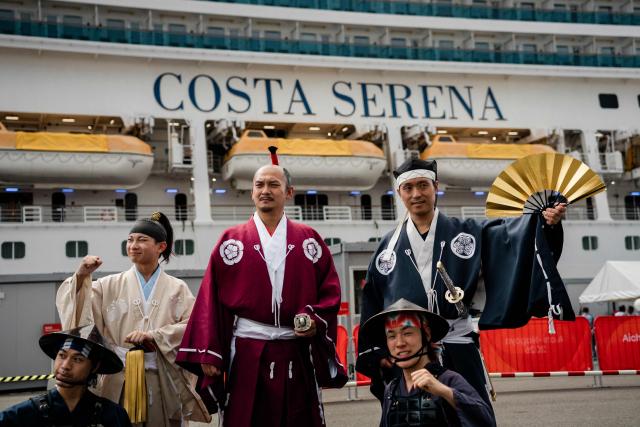 Members of the Nagoya Omotenashi Bushotai traditional samurai performance group pose in front of the Costa Serena cruise ship following its arrival at the Port of Nagoya in Nagoya, Aichi prefecture on September 15, 2026. (Photo by Fred Mery / AFP)