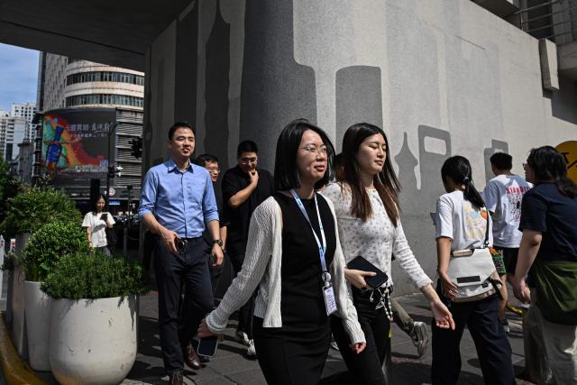 People cross the pedestrian road on a street in Shanghai on September 15, 2026 (Photo by Jade GAO / AFP)