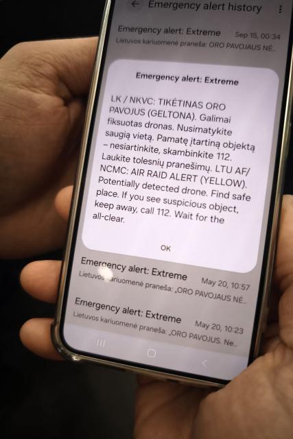 A phone displays the alert message sent to the public, warning about a possible drone attack in Vilnius on September 15, 2026. NATO fighter jets shot down a drone over Lithuania, the president of the Atlantic Alliance member country, Gitanas Naus?da, announced. (Photo by Petras MALUKAS / AFP)