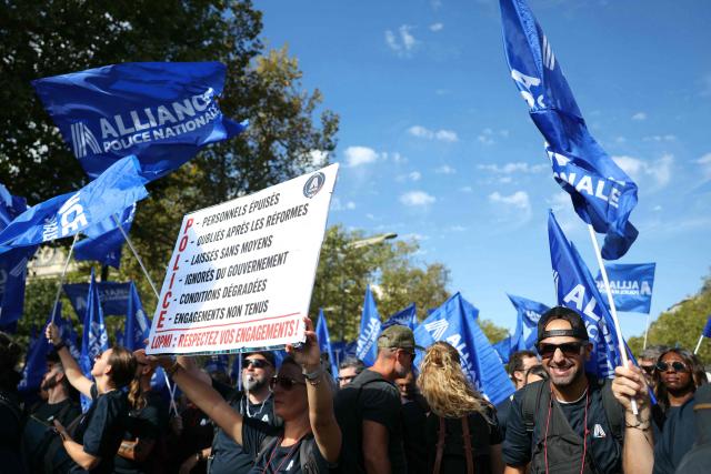 French police officers wave union flags during a demonstration at the call of French union Alliance Police Nationale demanding pay increases, more resources and greater recognition in Paris on September 15, 2025. (Photo by Thomas SAMSON / AFP)