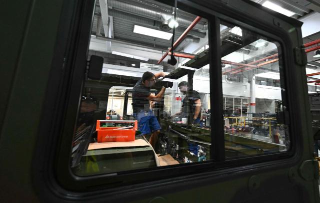 Employees work at a military vehicle during a visit of the Austrian Chancellor at the Rheinmetall MAN Military Vehicles (RMMV) plant in Vienna-Liesing, Austria, on September 15, 2026. (Photo by Joe Klamar / AFP)