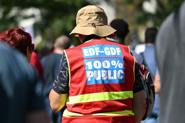 A protestor wears a union jersey reading "EDF GDF 100% public" during a demonstration at the call of several workers' unions of the electricity and gas sector against a government plan to remove the "tarif agent", a preferential energy rate on electricity and gas consumption for employees and retirees of the electricity and gas industries, near France's Economy ministry Bercy in Paris on September 15, 2026. Electricity and gas workers staged a massive strike on September 15, 2026, to protest plans to roll back their preferential energy rates, a benefit that is part of their compensation package, with some 59% of EDF SA employees (excluding subsidiaries) participating by midday, according to management. This level of participation, calculated on the company’s total workforce, is “historic,” according to the CFE-CGC, the company’s leading union, which notes that it already exceeds the participation rate recorded at the end of the day during the previous action to defend the employee tariff in 2011. (Photo by LOU BENOIST / AFP)