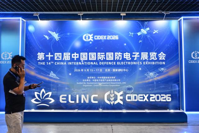 A man walks past signage of the 14th China International Defence Electronics Exhibition (CIDEX) in Beijing on September 15, 2026. (Photo by ADEK BERRY / AFP)
