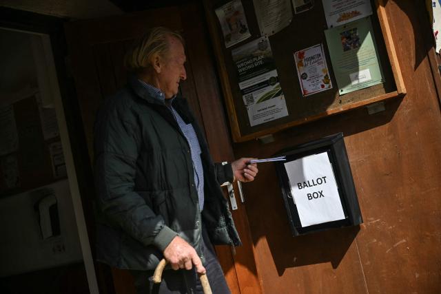 A resident places his ballot in a box at the local village hall in Piddington, Oxfordshire, north-west of London on September 15, 2026, as the town of fewer than 400 inhabitants votes on a symbolic referendum on leaving the UK. (Photo by JUSTIN TALLIS / AFP)