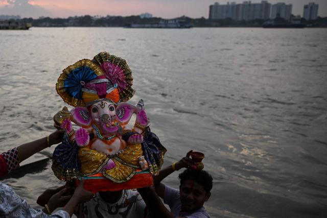 Devotees prepare to immerse an idol of the elephant-headed Hindu deity Ganesha in the holy river Ganga during the ongoing Ganesh Chaturthi festival in Kolkata on September 15, 2026. (Photo by Dibyangshu SARKAR / AFP)