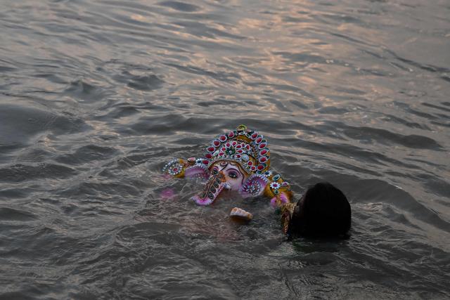 A devotee immerses an idol of the elephant-headed Hindu deity Ganesha in the holy river Ganga during the ongoing ‘Ganesh Chaturthi’ festival in Kolkata on September 15, 2026. (Photo by Dibyangshu SARKAR / AFP)