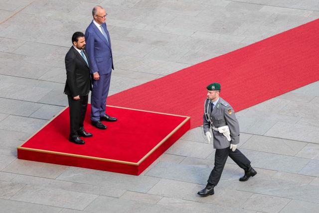 German Chancellor Friedrich Merz (R) and Iraq's Prime Minister Ali Falih Kadhim al-Zaidi stand on the podium to listen to their national anthems as they review a military honor guard in front of the Chancellery in Berlin on September 15, 2026. (Photo by Fabrizio Bensch / POOL / AFP)