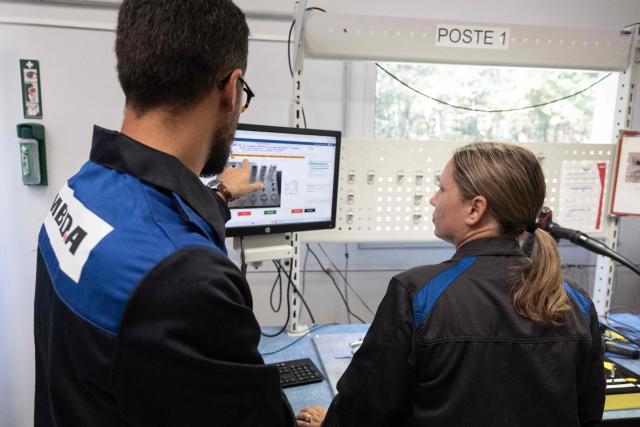 A trainer (L) gestures as he desmonstrates to an employee at the training and learning center of the MBDA multinational group plant, a corporation that designs and manufactures missiles and weapons in Selles-Saint-Denis on September 15, 2026. On September 15, 2026, the European missile manufacturer MBDA confirmed to AFP its plan to set up a new production site near Orléans, intended to support the sharp ramp-up in its missile production and which could eventually employ 400 people. (Photo by Alain JOCARD / AFP)