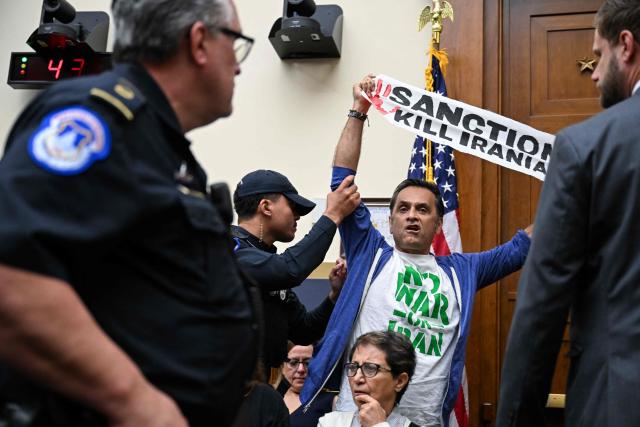 A demonstrator protesting the war in Iran and US sanctions on Iran is removed by Capitol Police officers as US Treasury Secretary Scott Bessent (out of frame) testifies during a House Financial Services Committee hearing on the state of the international financial system on Capitol Hill in Washington, DC, on September 15, 2026. (Photo by ROBERTO SCHMIDT / AFP)