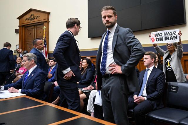 A demonstrator (R) protests the war in Iran as US Treasury Secretary Scott Bessent (L) testifies during a House Financial Services Committee hearing on the state of the international financial system on Capitol Hill in Washington, DC, on September 15, 2026. (Photo by ROBERTO SCHMIDT / AFP)