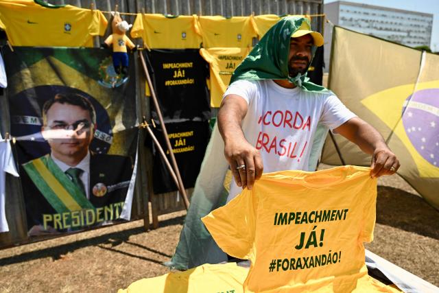 A vendor sells campaign merchandise supporting presidential candidate Flavio Bolsonaro outside the National Congress in Brasilia on September 15, 2026, during a hearing at Brazil's Supreme Federal Court (STF) on the investigation into alleged links between Supreme Court Justice Alexandre de Moraes and banker Daniel Vorcaro. Brazil's Supreme Court on September 15 began examining one of its top justice's ties to a jailed banker, in an unprecedented crisis that has eclipsed the country's presidential election campaign. (Photo by Evaristo Sa / AFP)