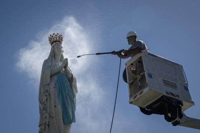 A worker cleans a statue of the Crowned Virgin, in Lourdes on September 15, 2026. Pope Leo XIV will travel to Lourdes, a site of pilgrimage for Christians worldwide, where he will hold an open-air mass on Sunday, September 27, before presiding over another at the cathedral in the northeastern city of Metz on September 28. (Photo by Ed JONES / AFP)