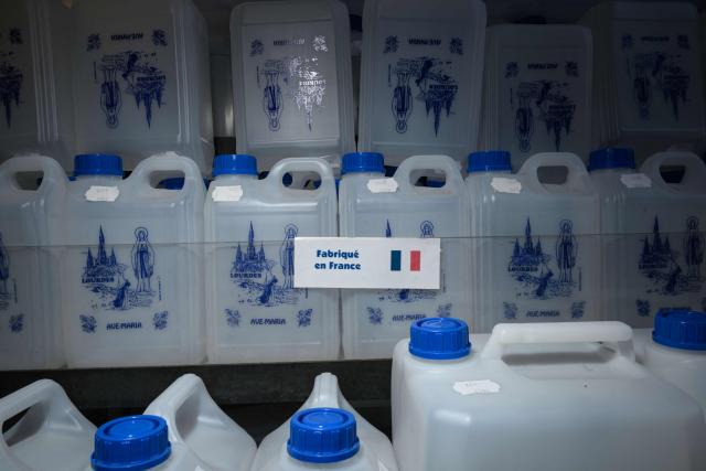 This photograph shows holy water bottles displayed at a shop in Lourdes on September 15, 2026. Pope Leo XIV will travel to Lourdes, a site of pilgrimage for Christians worldwide, where he will hold an open-air mass on Sunday, September 27, before presiding over another at the cathedral in the northeastern city of Metz on September 28. (Photo by Ed JONES / AFP)