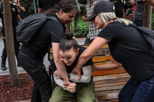 Turkish anti riot police officers attempt to detain a protester during a demonstration against the arrests and growing targeting of LGBTQ activists in Ankara, on September 15, 2026. Turkish police arrested dozens of people on September 13 in gay bars and at the homes of LGBTQ activists on charges including "obscenity", "assisting prostitution" and having "financial links abroad". Authorities have blocked social media accounts belonging to human rights defenders and media outlets as part of operations dubbed "My Family Is Safe. (Photo by Adem ALTAN / AFP)