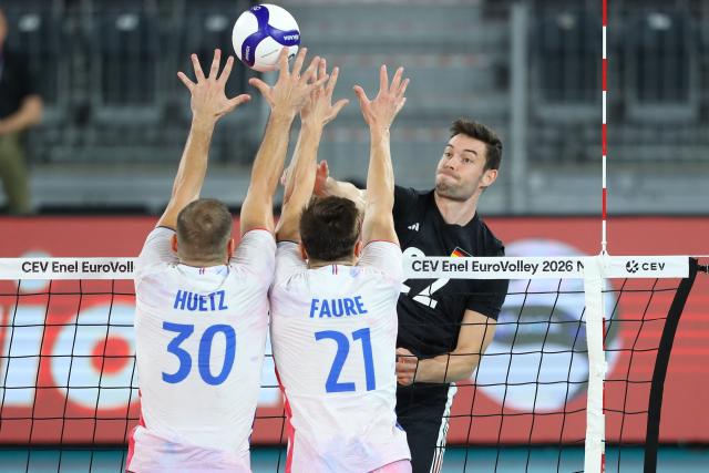 Germany's Tobias Brand spikes the ball against France's Francois Huetz and France's Theo Faure during the Men's EuroVolley 2026 match between France and Germany at the BT Arena in Cluj-Napoca, Romania, on September 15, 2026. (Photo by Simion Sebastian Tataru / AFP)