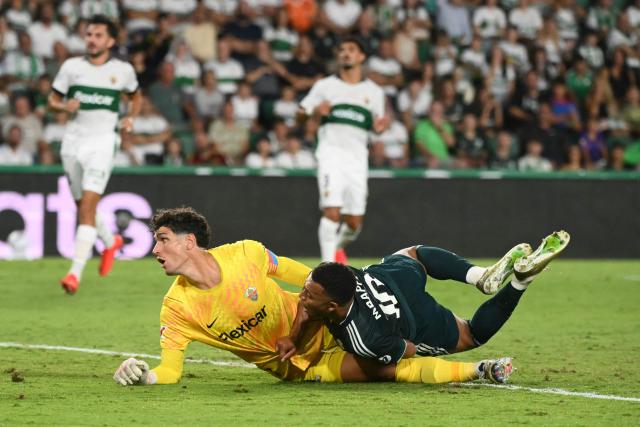 Real Madrid's French forward #10 Kylian Mbappe falls down to the ground next to Elche's Argentine goalkeeper #01 Matias Dituro after scoring his team's second goal during the Spanish league football match between Elche CF and Real Madrid CF at Martinez Valero Stadium in Elche on September 15, 2026. (Photo by JOSE JORDAN / AFP)