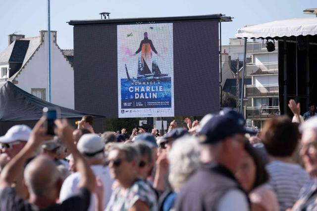 Attendees gather watch sail boats navigate as part of a maritime tribute to the late sailor Charlie Dalin, in Concarneau, in Brittany, western France on September 15, 2026. French offshore sailor and Vendee Globe 2024/2025 winner Charlie Dalin has died in Quimper, western France, aged 42, from cancer, his family announced on June 11, 2026. (Photo by Oscar Chuberre / AFP)