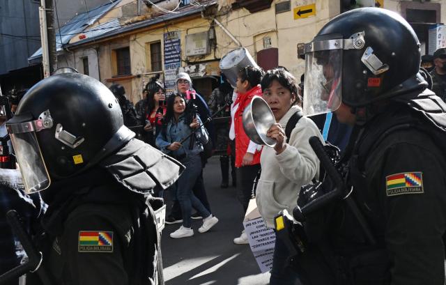 Bolivian police officers stand guard in a protest by education workers banging pots against the Bolivian government in La Paz on September 15, 2026. (Photo by Aizar RALDES / AFP)