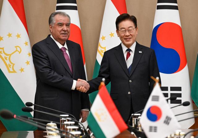 Tajikistan's President Emomali Rahmon (L) shakes hands with South Korea's President Lee Jae Myung during their meeting at the presidential Blue House in Seoul on September 16, 2026.  (Photo by SONG Kyung-Seok / POOL / AFP)