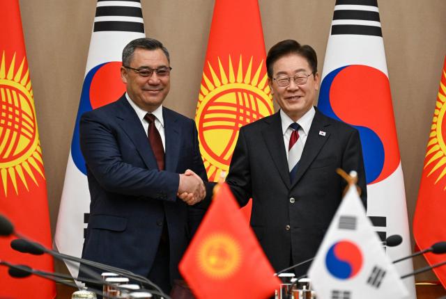 Kyrgyzstan's President Sadyr Japarov (L) shakes hands with South Korea's President Lee Jae Myung during their meeting at the presidential Blue House in Seoul on September 16, 2026.  (Photo by SONG Kyung-Seok / POOL / AFP)