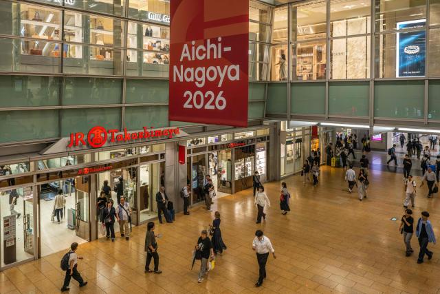 People walk under a banner promoting the 2026 Asian Games at the train station in Nagoya, Aichi Prefecture on September 16, 2026. (Photo by Mohd Rasfan / AFP)