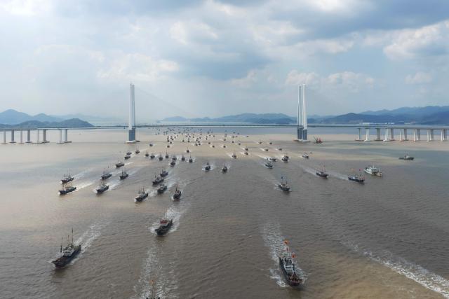 Fishing boats pass under the Xiangshan Port Bridge in Ningbo, in eastern China's Zhejiang Province on September 16, 2026. (Photo by CN-STR / AFP) / China OUT