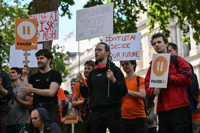 People hold placards during a "emergency protest" by civic action group PauseAI UK outside Downing Street in central London on September 16, 2026, after news that AI researcher Jacob Coxon has decided to leave the industry. The world's biggest AI companies are working on creating a standards body, ChatGPT-maker OpenAI said on September 15, as fears rise about the dangers of AI and pressure is on to create a safer version of the technology. Earlier this month researcher Coxon, who had previously worked at OpenAI, left Anthropic and warned that AI labs were "gambling with our lives." (Photo by JUSTIN TALLIS / AFP)