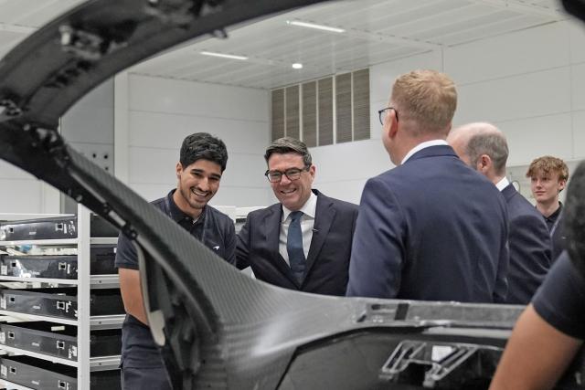 Britain's Prime Minister Andy Burnham (C) smiles during a visit to meet apprentices and workers on the production lines at the McLaren Technology Centre in Woking, Surrey, south-west of London on September 16, 2026. (Photo by Stefan Rousseau / POOL / AFP)