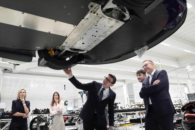 Nick Collins (R), chief executive officer of McLaren Group, looks on as Britain's Prime Minister Andy Burnham (C) looks at a car on the production line during a visit to the McLaren Technology Centre in Woking, Surrey, south-west of London on September 16, 2026. (Photo by Stefan Rousseau / POOL / AFP)