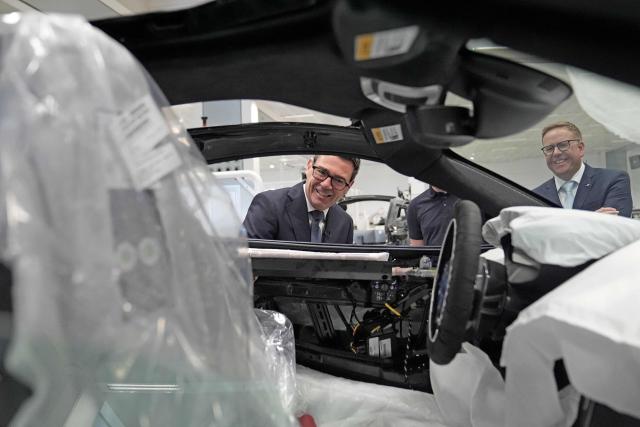 Nick Collins (back R), chief executive officer of McLaren Group, looks on as Britain's Prime Minister Andy Burnham (C) looks at a car on the production line during a visit to the McLaren Technology Centre in Woking, Surrey, south-west of London on September 16, 2026. (Photo by Stefan Rousseau / POOL / AFP)