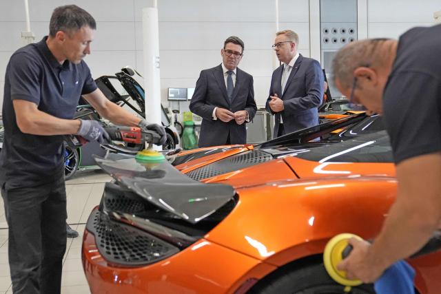 Nick Collins (centre R), chief executive officer of McLaren Group, speaks with Britain's Prime Minister Andy Burnham (centre L) during a visit to meet apprentices and workers on the production lines at the McLaren Technology Centre in Woking, Surrey, south-west of London on September 16, 2026. (Photo by Stefan Rousseau / POOL / AFP)