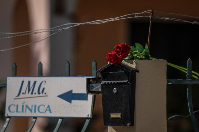A picture taken on September 16, 2026 shows a sign indicating a medical office and flowers displayed on the mailbox at the entrance of a house where two persons - a 79-year-old French citizen according to media, and his 62-year-old partner - have been killed in Lagos, Algarve. A 79-year-old man, a Frenchman according to media, and his 62-year-old partner were killed by another 45-year-old foreigner who was guarding their house in southern Portugal, authorities said. A statement from the judicial police specifies that the suspect was arrested on September 12, 2026 with the help of the gendarmerie of Lagos, in the tourist region of the Algarve, where many foreigners live. (Photo by PATRICIA DE MELO MOREIRA / AFP)