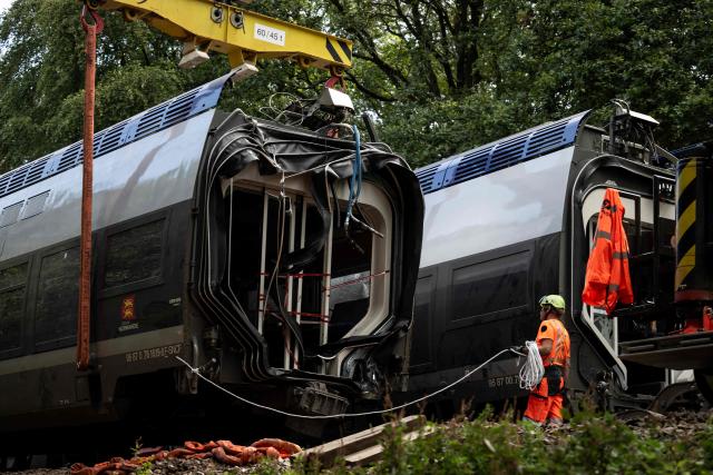A railway worker works on the removal of a derailed train carriage in Cleon, northwestern France, on September 16, 2026. France's interior minister on September 13 urged caution as authorities investigated the derailment of a train that injured 44 people, amid questions over whether the incident could have been an act of sabotage. The train, carrying 186 passengers, derailed on September 11 between the Normandy cities of Rouen and Caen in northwestern France, leaving many badly shaken, officials said. (Photo by Guillaume SALIGOT / AFP)