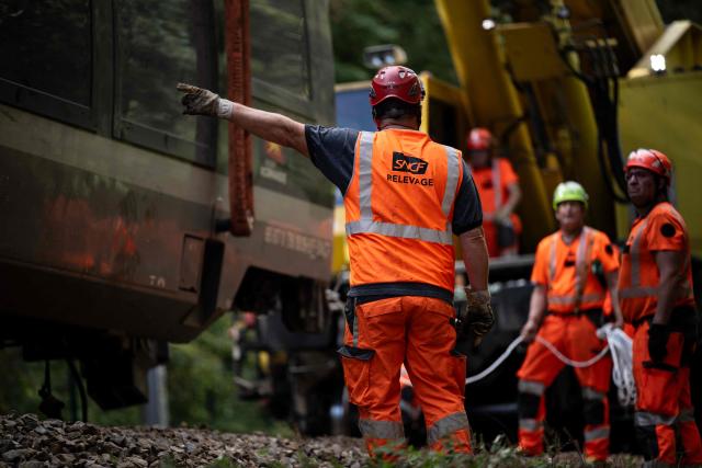 Railway workers oversee the removal operation of a derailled train carriage in Cleon, northwestern France, on September 16, 2026. France's interior minister on September 13 urged caution as authorities investigated the derailment of a train that injured 44 people, amid questions over whether the incident could have been an act of sabotage. The train, carrying 186 passengers, derailed on September 11 between the Normandy cities of Rouen and Caen in northwestern France, leaving many badly shaken, officials said. (Photo by Guillaume SALIGOT / AFP)