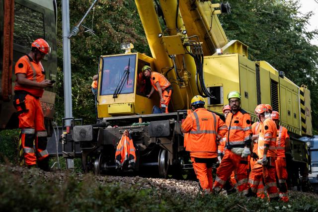 Railway workers work on the removal of a derailed train carriage in Cleon, northwestern France, on September 16, 2026. France's interior minister on September 13 urged caution as authorities investigated the derailment of a train that injured 44 people, amid questions over whether the incident could have been an act of sabotage. The train, carrying 186 passengers, derailed on September 11 between the Normandy cities of Rouen and Caen in northwestern France, leaving many badly shaken, officials said. (Photo by Guillaume SALIGOT / AFP)