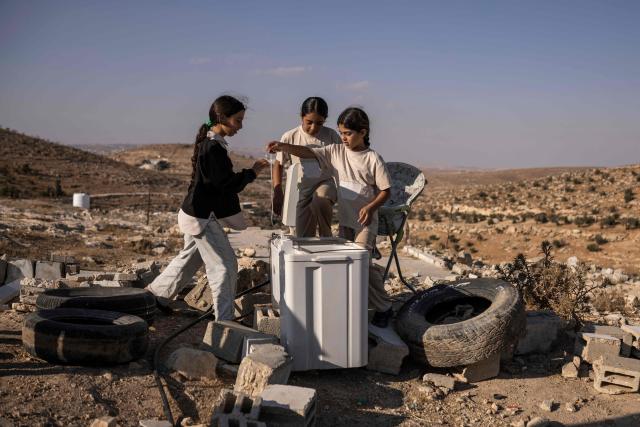 Three of Mohammed Fadel Amr’s daughters, Ni’ameh (L), Bisan (C) and Hadeel, stand on the ruins of their old home in the village of Al-Tuwani, in the Israeli-occupied West Bank, on September 11, 2026. After his home was destroyed by Israeli forces in 2023, Mohammed Fadel Amr took shelter in caves, where he now lives with his two wives, Fatma Amr and Arwa Amr, and their eleven children. Mohammed and his family say they face almost daily harassment from settlers living in a nearby illegal Israeli settlement outpost. At the end of August 2026, Israeli forces reportedly ransacked the family's makeshift home during a night raid, and settlers later stole his goats, depriving him of his livelihood. (Photo by John WESSELS / AFP)