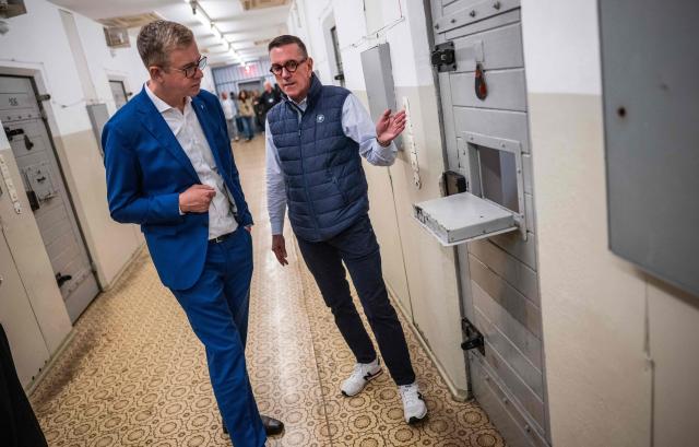 Berlin's senator for culture Stefan Evers (L) listens to former inmate Mario Roellig (R) as he visits the former prison of the East German communist-era secret police, known as the Stasi, at Hohenschoenhausen in Berlin on September 16, 2026. The complex, now a museum and memorial, included interrogation and detention facilities as well as underground cells where the regime's critics underwent relentless psychological torture. Evers is the Christian Democratic Union's (CDU) main candidate in upcoming regional elections in Berlin. (Photo by John MACDOUGALL / AFP)