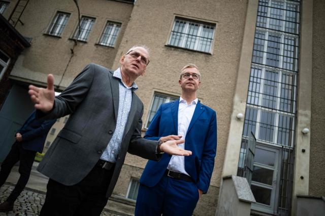 Berlin's senator for culture Stefan Evers (R) listens to former inmate Christian Koenig (L) as he visits the former prison of the East German communist-era secret police, known as the Stasi, at Hohenschoenhausen in Berlin on September 16, 2026. The complex, now a museum and memorial, included interrogation and detention facilities as well as underground cells where the regime's critics underwent relentless psychological torture. Evers is the Christian Democratic Union's (CDU) main candidate in upcoming regional elections in Berlin. (Photo by John MACDOUGALL / AFP)