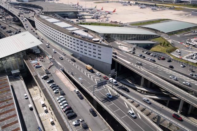 (FILES) Cars cross different motorways outside the Roissy-Charles de Gaulle Airport, in Roissy, north of Paris, on June 27, 2019. Environmental associations denounced on September 14, 2026 the expansion of Paris-Charles de Gaulle airport planned until 2035, calling for the abandonment of a project they describe as "incompatible" with France's climate objectives. The project envisages a new boarding building, an entirely new internal rail line, a redesigned terminal access, a bill of 8.2 billion euros over eight years and, ultimately, capacity for an additional 18 million annual passengers by 2035, which would bring the total close to 90 million per year. (Photo by JOEL SAGET / AFP)