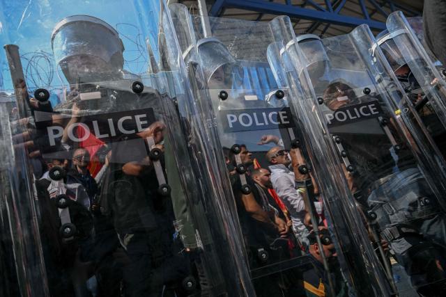 Riot police officers stand guard  as people protest in front of the EULEX headquarters in Pristina on September 16, 2026, after the Kosovo Specialist Chambers in The Hague convicted former Kosovo president Hashim Thaci and three former guerrilla commanders of war crimes. Kosovo's former president Hashim Thaci was sentenced to 25 years by a tribunal in The Hague on September 16, 2026 for war crimes, the court said in a long-awaited verdict likely to spark outrage in the Balkan country. (Photo by Armend NIMANI / AFP)