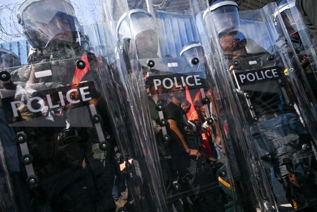 Riot police officers stand guard  as people protest in front of the EULEX headquarters in Pristina on September 16, 2026, after the Kosovo Specialist Chambers in The Hague convicted former Kosovo president Hashim Thaci and three former guerrilla commanders of war crimes. Kosovo's former president Hashim Thaci was sentenced to 25 years by a tribunal in The Hague on September 16, 2026 for war crimes, the court said in a long-awaited verdict likely to spark outrage in the Balkan country. (Photo by Armend NIMANI / AFP)