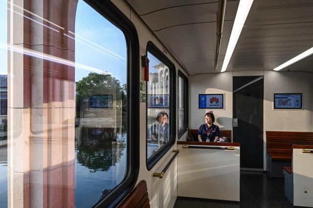 A Huawei employee travels on a shuttle train at Huawei Lianqiu Lake research campus during a media tour in Shanghai on September 16, 2026. (Photo by Jade GAO / AFP)