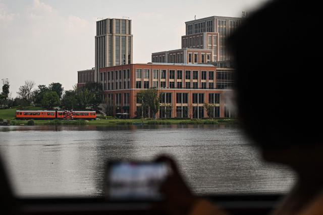 A shuttle train runs through the Huawei Lianqiu Lake research campus during a media tour in Shanghai on September 16, 2026. (Photo by Jade GAO / AFP)